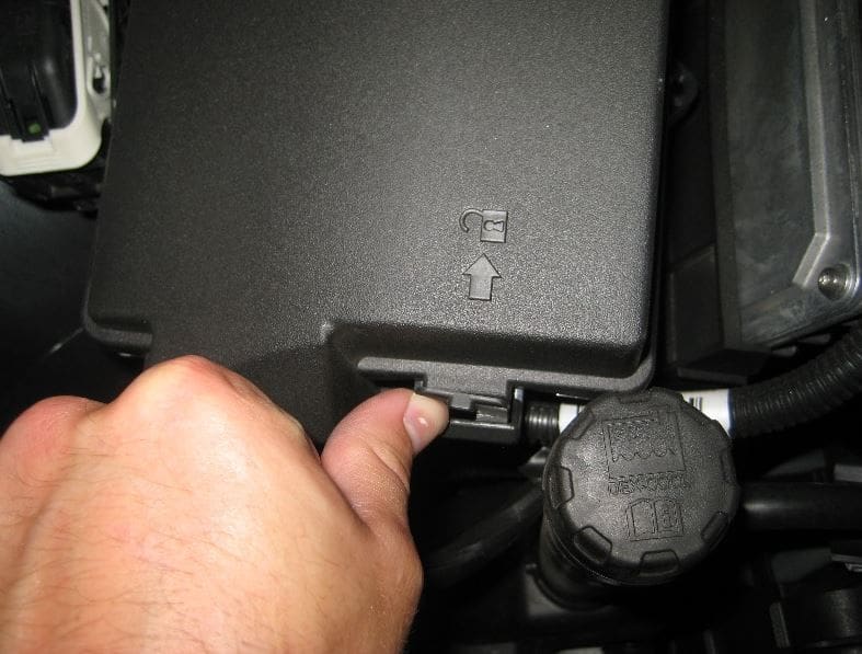 Figure 6. To open the engine compartment fuse box, unlock the front tab and swing the cover up.