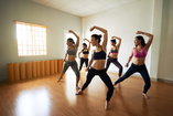 A group of woman exercise together in a group dance class during their addiction recovery.