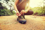 Person ties shoe before embarking on a hike