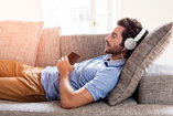 Man relaxing with music to calm his nerves during recovery.