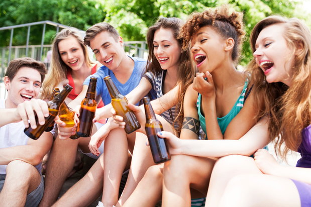 group of young friends cheering with beer