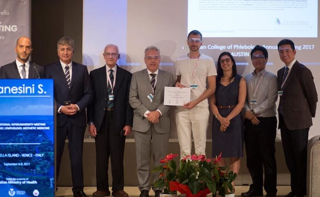 Sergio Gianesini, MD, PhD with abstract award winners on stage