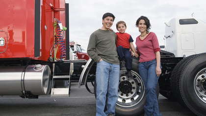 Family standing next to red truck