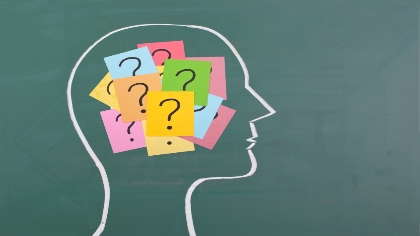 A profile of a head with post-its that have question marks on them.   