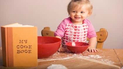 A toddler baking in the kitchen. 