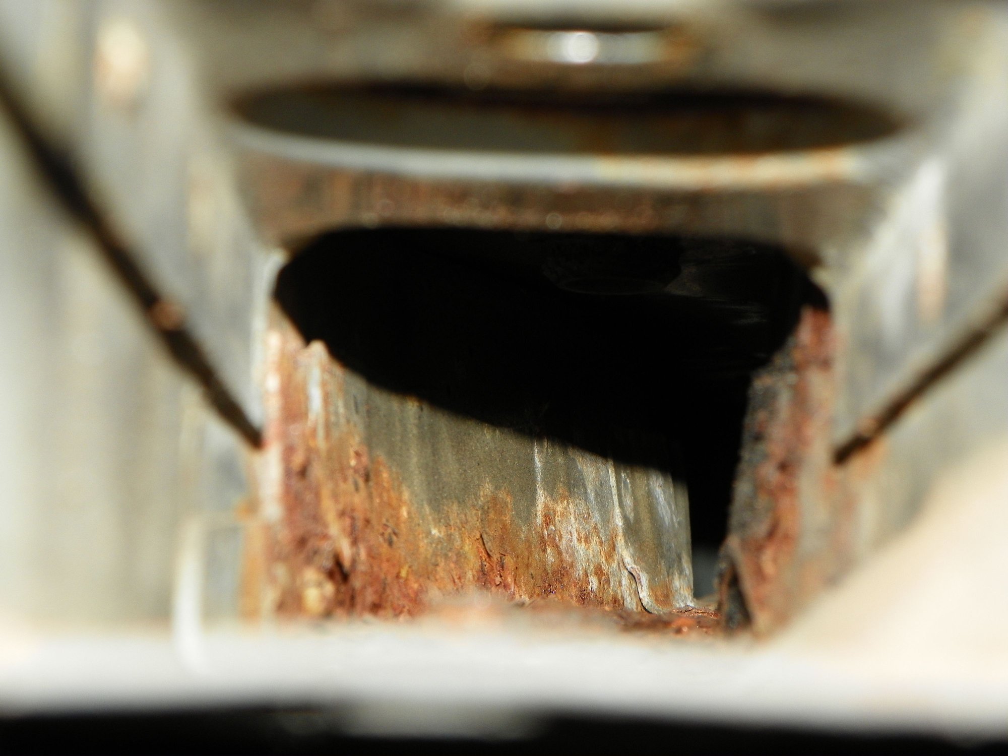 Inside of left frame. YUCK! For now I've fluid filmed it to stop the corrosion, but I'm gonna see if I can find a comically long wire brush to fit on my drill to remove this and then paint it.