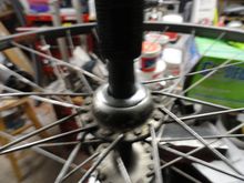 Installed in the hub and capturing the dust caps.