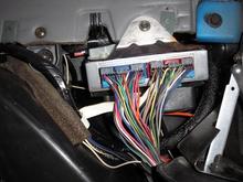Getting to the 4WD TCCM, after removing the RH kick panet and removing the lower I/P trim panel, the picture shows the TCCM mounted on the ECM (Electronic Control Module) just below the glove box.