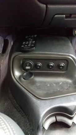 Removed cassette deck and replaced with custom made switch panel.  You can also see the AUX port with 3.5mm audio and USB mounted in the panel.