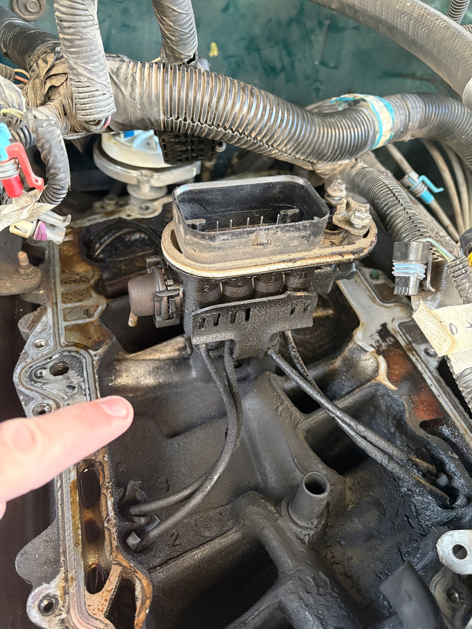 In this photo I was just pointing at a clean spot. It is because this fuel pressure regulator is bad. I have the manifold off to replace the fuel injector spider. You can see how dirty it is. I think there is even a little oil in some spots. 