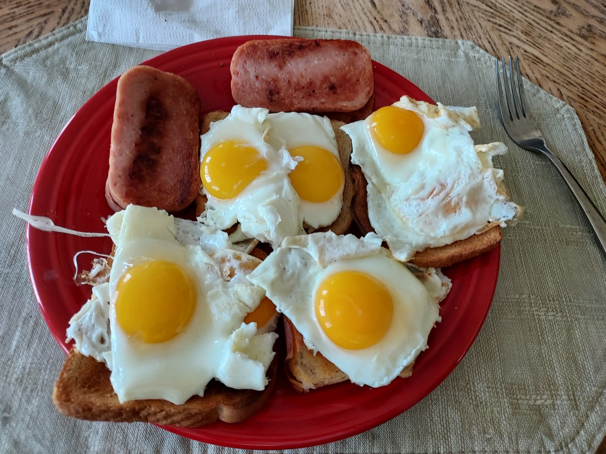 Two sunny-side up eggs on wheat toast (one egg on leftover biscuit), with 4 slices of fried SPAM on the side.  Should meet my protein needs for the day!