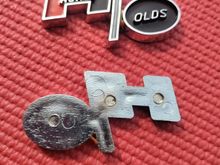 Hurst Olds Emblem. Aftermarket. I believe that these are 73-75 console emblems. Other suppliers indicate them as being used on 69-72 also. Emblem measures 2 1/2" x 1 1/4". They are made of molded plastic chrome. Does not have sticky back.
$20 each.