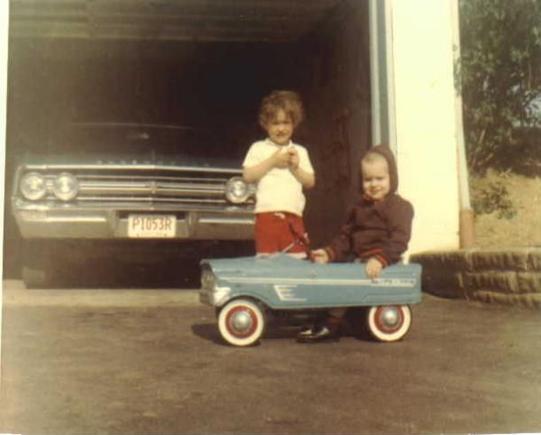 Thats me in the peddle car, my sister and my car watching over me in the garage, sometime around 1970