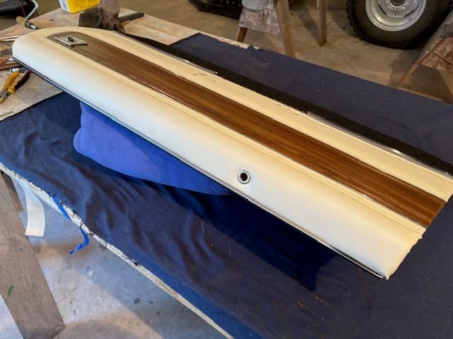 Here I have reattached the top piece of steel and completed most of the vinyl work.  Fairly easy to do since there are no compound curves on the door panel.  Cleaned up and cut in the door lock grommet.