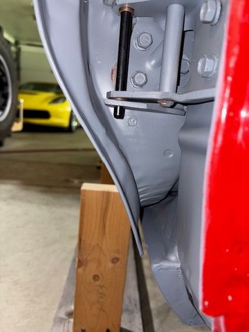Here you can see that the door bottom needs moved inward.  So a floor jack and block of wood supports the door while cap screws are loosened and the door bottom moved inward.  Again, lots of loosening, repositioning, tightening, and observing the door to see if it is fitting better.