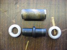 Piece of oil impregnated brass bushing material, above original part.