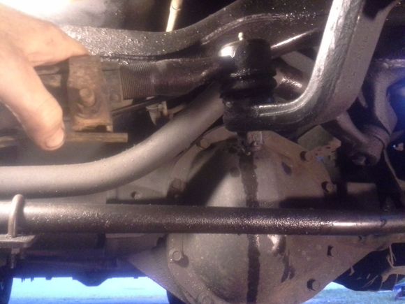 Can twist/turn this part a 1/4 turn effortlessly. That normal though? That fluid leaking back there is pwr steering fluid. Another issue, needs a new hose! That bar is the "y" bar with the screen door piece I was talking about. To the left it goes to the ball joint that has slits in boot and no grease in it anymore. Almost all the boots under here has slits from dryrot and all the bushings everywhere are rotted as well! Think that's part of the prob?