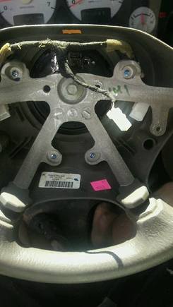 steering wheel that shows the white plug. Also note on the far right side that the metal tabs are where the air bag bolts in and just below that is the plastic housing where the switches screw in 