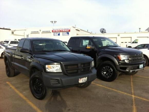 Finally have all the chrome gone. Added 16" V-Tec Raptor black rims. Speaking of Raptors look at my Dak put that one too shame, she ain't so "mid-sized" next to that f-1(shitty), really stands her ground. Also by this time I had added 2" blocks to the rear.