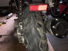 The bike is sitting level on a block. 
The rear tire cocked to the side and there is irregular wear. 