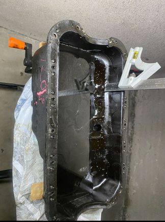 Here I did a test where I wanted to see where my oil line was. This is how much oil would be in a normal D16z6, and I have 2" of clearance to weld in my bung. Its right above the baffling. I have another photo of the inside of my current pan after the bung is welded on if that helps