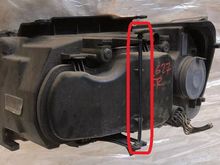 This is the rear view of the headlight assembly showing the plastic release tab and rod (I borrowed this photo from an eBay listing).