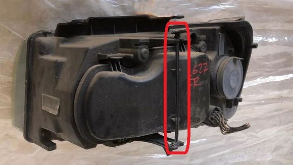 This is the rear view of the headlight assembly showing the plastic release tab and rod (I borrowed this photo from an eBay listing).