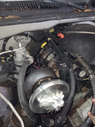 Preliminary fitment of the turbo with heater lines relocated and the AC line bent. 