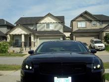 tinted headlights with black mesh grill and nismo logo . also have the nissan hood deflector