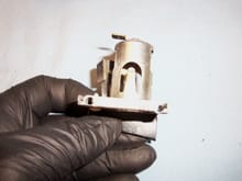 Cigar lighter showing one of the drilled through spot welds in its bracket.