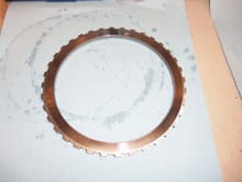 Inside steel plate. It is flat on this side, to engage the inside most clutch plate. This steel is supposed to be 7.7mm thick, as per WSM Volume 3. This steel is quite hefty compared to the others.