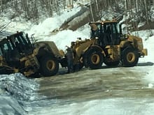 A loader off the road last winter sporting "all season tires" or better said, no chains. Here the second one (also without chains is trying to recover it from falling off the mountain