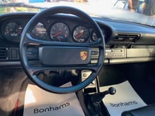 A 911 steering wheel with an integrated Porsche logo.