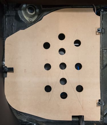 Instead of the original plastic cover, this plywood cover was fabricated. The holes were drilled to allow the sound to pass through and avoid rattling.
