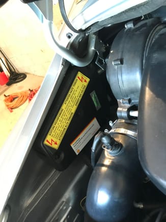 See the smaller white “Shell” sticker beneath the yellow “High Voltage” warning sticker.  Located along the driver’s side of the engine bay.