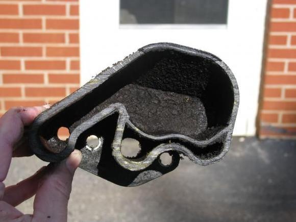 Oil trap/separator cut open.
This is view of bottom half.
Left hole leads to crank return tube.
Second hole from right is "in" from top of crank case.
Other two holes are the mounting holes.