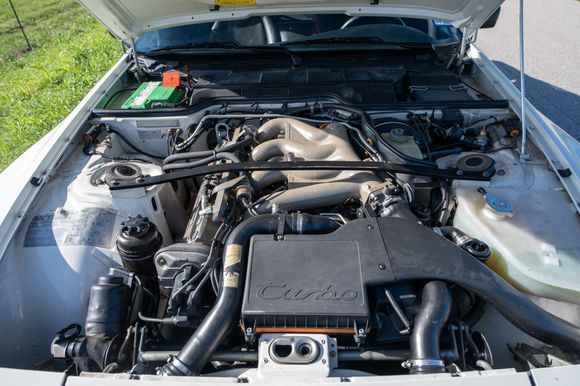 Engine compartment showing magnesium (tan) intake and all factory parts (strut brace, decals, etc.) intact. Fiberglass hood has original "kickstand" in place. 