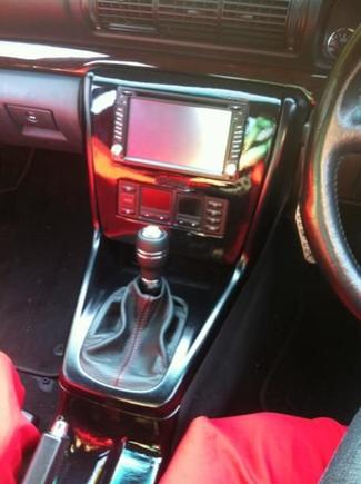 Got my DIY on with the center console.
Pulled out all the buttons and re-wired them into the glovebox. Hacked bits off the plastic framing so that a double din unit would fit; it now fits perfectly. Removed the ash tray and lighter and converted space to hold my iphone. Made a custom front plate out of fiberglass using the clips from the old one to hold it in place. Put a leather boot and a momo auto shifter to tidy up the ugly automatic look.