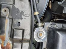 Around the radiator cap, and then finally out the same hole as the front sprayer hose and electrical connections. I bought a total of ten feet of hose, and used like nine and a half.