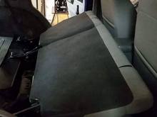 Folds almost flat. Could be folded flat if you wanted to remove the cross braces the factory seat sits on.