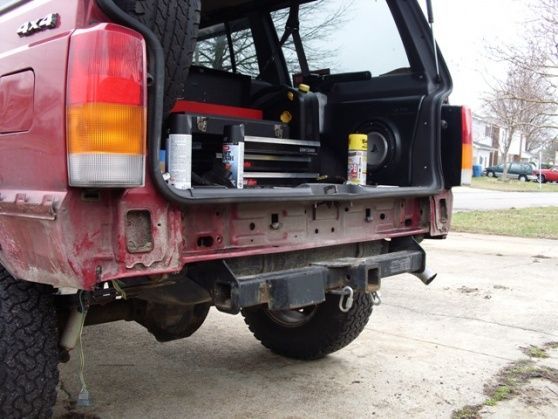 The L-brackets go into the sub-frame, tying everything to it and the rear body panel between the gas tank and the bumper.  It's pretty strong.