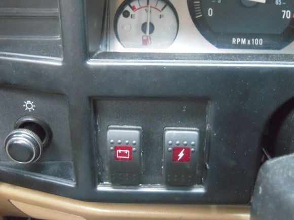 Left switch is to charge the secondary battery, right switch is to use it.  When the key is out and ignition off, the right switch can be used to power the accessories without using any power from the main (starting) battery.  Everything is done with relays or solenoids, so all the power isn't running through these switches...