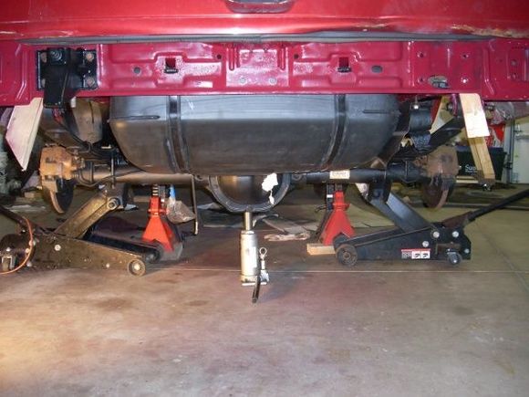 Getting there. Installing rear axel. Removed crummy red lift gate and had green one painted red. Axel has now been rotated to match pinion angle to TC. Welded new perches on.