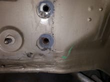I'm assuming the car was repaired at some point.  It seems unlikely the factory would have done shoddy work like this.  I  used a dremel tool to open up the hole enough to get a new bolt in.