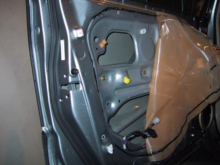 The black sealant line around the tan cover used to help shield the window motor and regulator. 