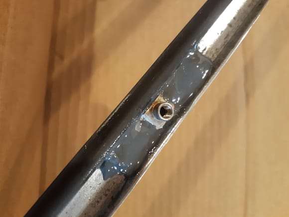 There is no practical way to weld new staking pins, or weld the nut strips onto the stainless steel frame without burning the insert molded rubber, so after burnishing mating surfaces used JB Weld metal reinforced epoxy to reaffix the tapped strips. Mind the small and large index hole orientation.
