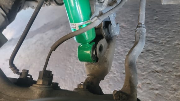 One bolt in the bottom of the strut. Use a hydraulic jack to hold the bottom of the shock