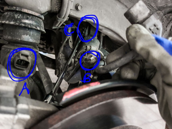 EPB plug (A) and its wire mount (B) have to be removed before the upper damper bolt (C) can be loosened. Use a 17mm swivel ratchet box wrench.
