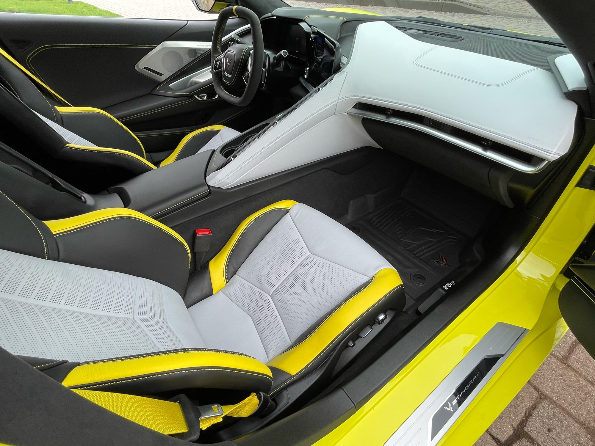 Interior gris celeste con cinturones de seguridad y costuras en amarillo llamativo Corvette C8