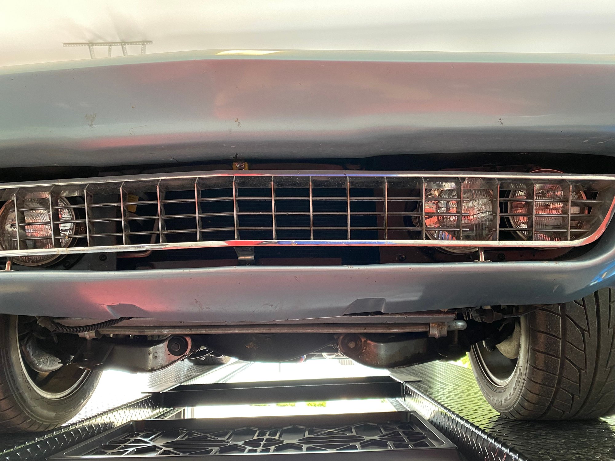 Definitely a one piece front end. When the part came out of the mold, this opening was closed. Instead of cutting out the whole area they left the ends and bolted the headlights to them.